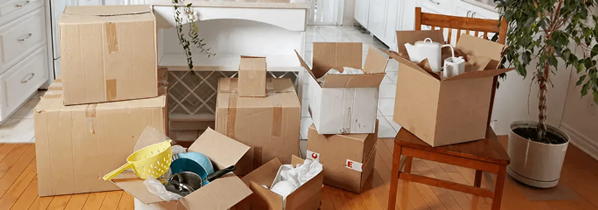 Packed moving boxes and household items in a kitchen before move-out or move-in cleaning, Huntsville, AL.